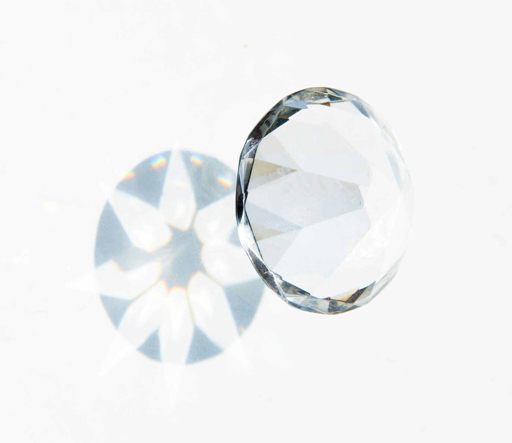 A detailed image of a faceted diamond showcasing a prism effect on a clean white background.